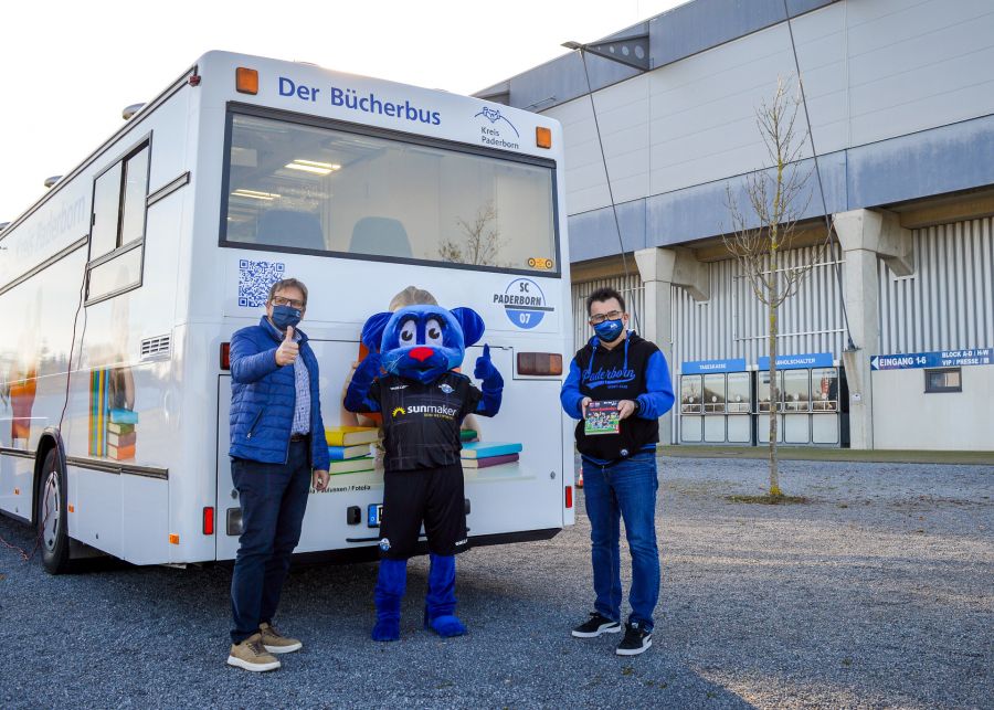 Bringen zum Vorlesetag den Lese Spaß nach Hause – v.l. Heinz-Josef Struckmeier (Kulturamt des Kreises Paderborn), Maskottchen Holli und SCP 07 Geschäftsführer Martin Hornberger.  Foto: Kreis Paderborn, Kulturamt, Diana Ramme